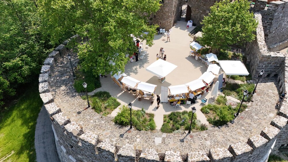 Mercato allestito nel cortile di un castello, vista aerea
